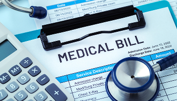 Medical bill on a clipboard with a stethoscope and a calculator